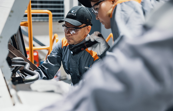 Wärtsilä employees in front of an engine